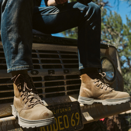 Man wearing 5.11 Tactical Rambler 6-inch Boots in Dark Coyote, sitting on a 4WD